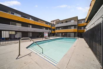 A small pool in a courtyard surrounded by buildings.